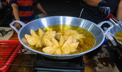Bakso mekar is fried in a frying pan full of oil. Fried meatballs are street snacks served with sauce and mayonnaise.