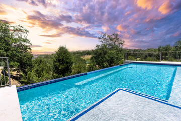 Relaxing by the infinity pool at sunset with beautiful sky and landscape