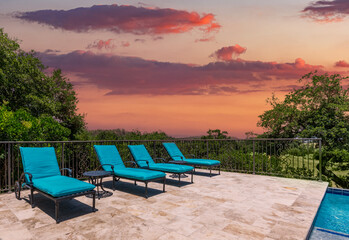 Sunset lounge by the pool with vibrant sky and tranquil surroundings