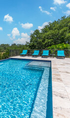 Sunny poolside retreat with lounge chairs and serene landscape view