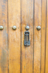 Fototapeta premium Close up of old Key in wooden door at home, Brown Wood Front Door with Ornate Brass Skeleton Key,copy space..
