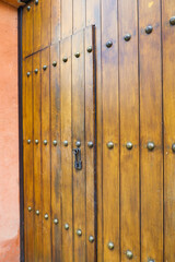 Obraz premium Close up of old Key in wooden door at home, Brown Wood Front Door with Ornate Brass Skeleton Key,copy space..