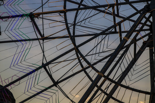 Close up silhouette of a rotating ferris wheel frame in an amusement park