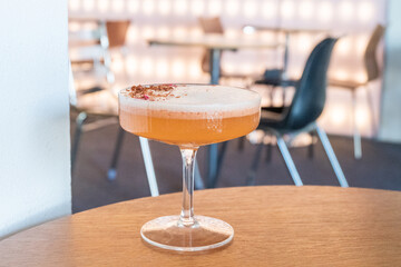 Glass of Cold Orange Mocktail on table,female hand swirling red wine in wine glass,Friends cheering with wineglasses.