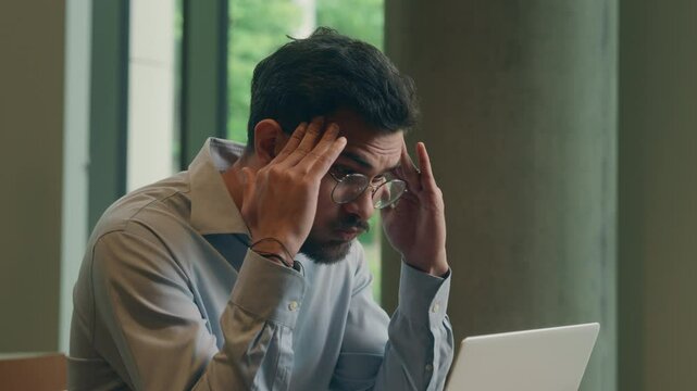 Arabian guy Indian businessman male employee manager in cafe business man customer stressed frustrated bad news laptop screen email message anxious sad crisis bankruptcy computer problem scam failure
