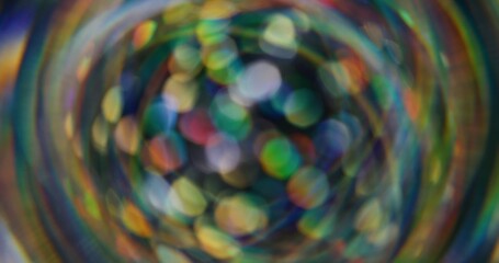 Blurred holographic confetti. Bokeh light. Defocused leak multicolor green yellow rays rainbow flickers beam lens flare on abstract art background.