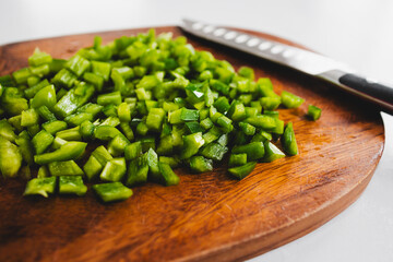 chopped up green bell peppers on wooden cutting board, natural healthy ingredients