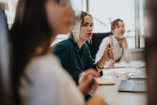 A multicultural group of business people engaged in a meeting, sharing insights and discussing strategies in a modern office setting. The environment conveys collaboration and teamwork.