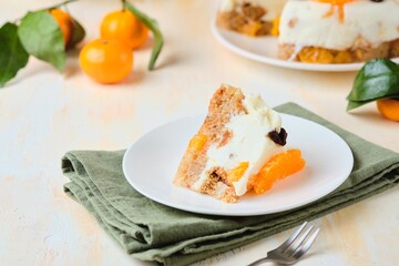 Jelly cake with a creamy part, spiced cupcake and tangerine on a white cake stand on a light concrete background. Dessert recipes