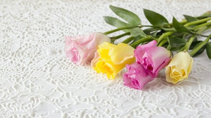 Pastel roses arranged on lace fabric.