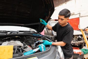 Young latin mechanic fixing a car engine