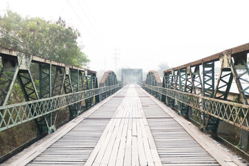 Obraz premium Old wooden Bridge with old railway ocated near street road and river.