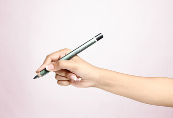 hand holding pencil on a plain background 