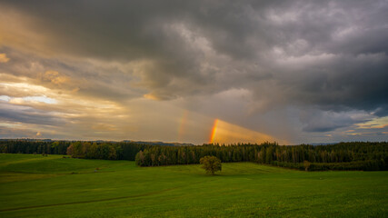 Fototapeta premium ein Regenbogen mit dramatisch bewölktem Himmel 