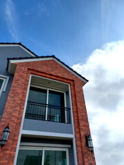 low angle view new home design using brick texture decorated on surface against blue sky white cloud