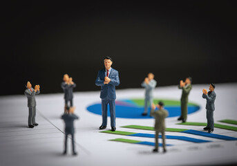 A small businessman stands atop financial charts and graphs, symbolizing success in the corporate world. Represents the concept of leadership and achievement, with miniature human figures set against 