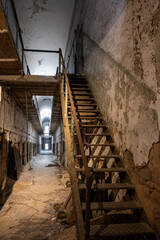 decrepit cell block and stairs leading to upper level at Eastern State Penitentiary historic site.