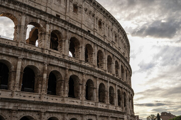 Arches archictecture of Colosseum (Colosseo) exterior with clouds and sky. Rome, Italy.