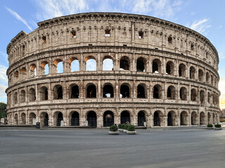 Fototapeta premium Arches archictecture of Colosseum (Colosseo) exterior with clouds and sky. Rome, Italy.