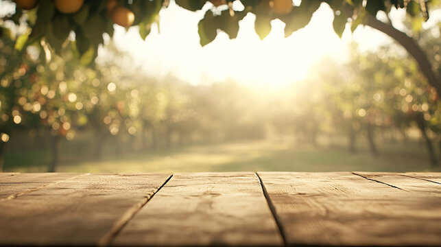 An empty wooden table with a slightly worn surface is positioned in the foreground. Behind it, the blurred view captures a sunny orchard filled with fruit trees and vibrant foliage, evoking the