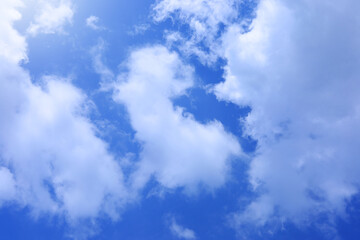 The sky is bright blue and the clouds are white. The sky during the day has pure white clouds like cotton. The sky background. 