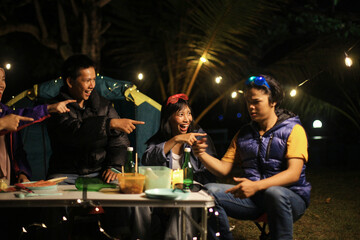 Friends Enjoying Outdoor Gathering at Night Around Campsite