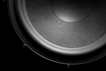 Subwoofer close-up. Powerful bass speaker on a black background.