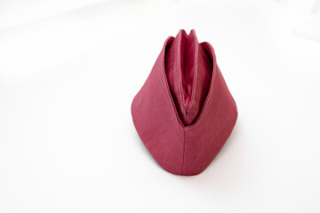 Burgundy side cap on a white background. A side cap is also known as a garrison cap or flight cap in the United States, wedge cap in Canada, or field service cap in the United Kingdom. 