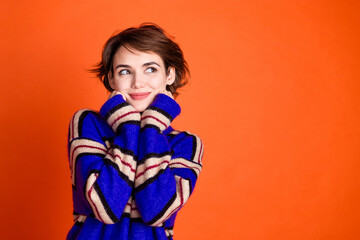 Photo of pretty lovely sweet woman wear stylish clothes arms touch face look empty space isolated on orange color background