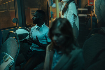 Black man wearing shorts and a t-shirt sitting on a bus