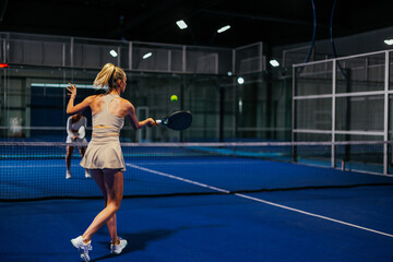Obraz premium Rear view of a female padel player playing padel