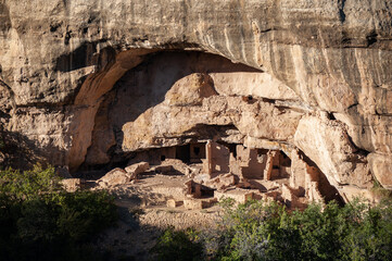 Ancient cliff dwelling ruins beneath a rocky overhang
