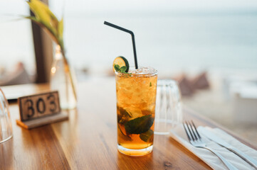 Refreshing Beverage with Lime and Mint on a Wooden Table at Beach