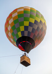 Fototapeta premium A colorful hot air balloon with a basket attached to it