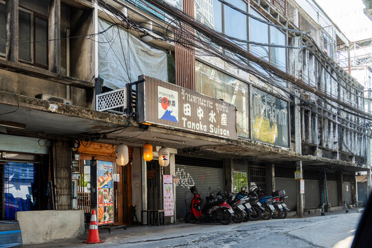 Bangkok, Thailand - November 28th 2024: Urban street view featuring closed shops and parked motorcycles in Thailanda