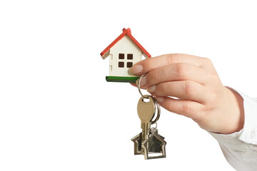 A female hand in a white shirt holding a small house and a key