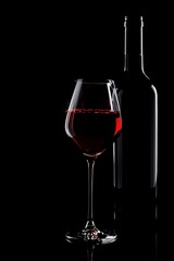 Elegant Glass of Red Wine with Bottle Against Black Background