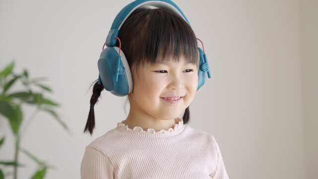 イヤーマフをした聴覚過敏の子供