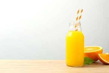 Bottle of freshly squeezed orange juice with citrus fruits on the table