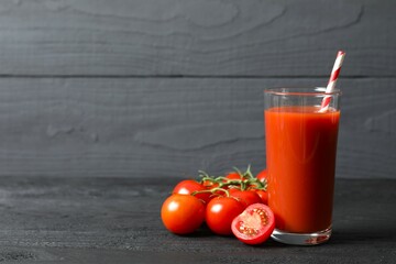Tomato juice in a glass and fresh tomatoes on the table
