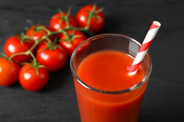 Tomato juice in a glass and fresh tomatoes on the table