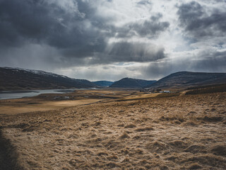 Paysage vallonné avec lac sous un ciel dramatique en Islande