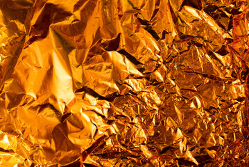 Seamless gold leaf background texture. Shiny golden yellow crumpled metallic foil repeat pattern. Modern abstract luxury gilded age wallpaper. Christmas glitter decoration backdrop. 3D rendering