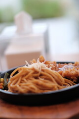 A delicious combination of crispy chicken and flavorful noodles served on a sizzling plate with vegetables