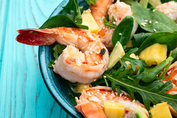 Salad with tiger shrimps , avocado and mango . Top view
