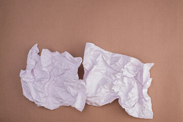 Crumpled white paper on a brown paper , ideal for notes or sketches.