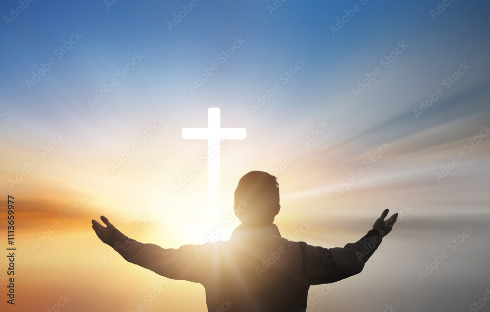 Wall mural silhouette of a man praying with a cross in the background