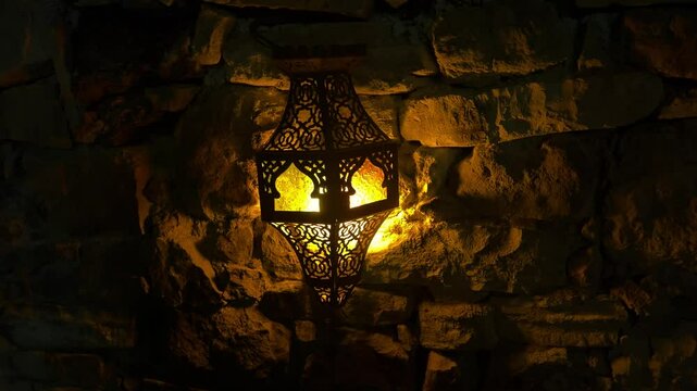Arabic wall lamp with flame imitation bulb in the evening. Outdoor decorative lamp.