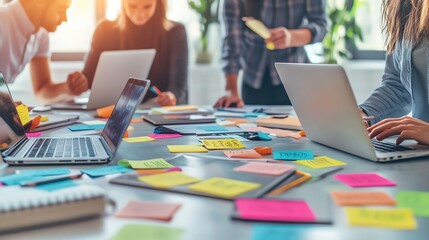 Team collaboration with laptops and sticky notes.