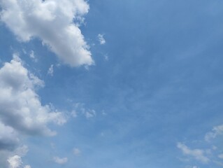 clear blue sky with a few clouds. The sky is very bright and the clouds are scattered throughout